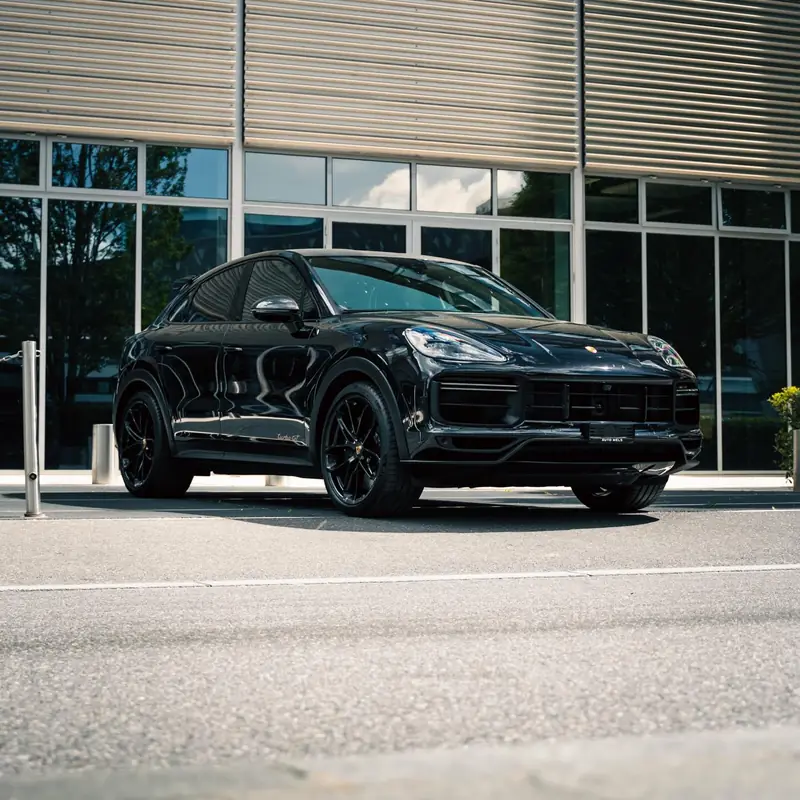 Porsche Cayenne Turbo GT noir devant une façade vitrée